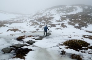 Ian Homer Photography. Ben Lomond climb: crossing the frozen burn (stream) on stepping stones between the Ptarmigan Ridge and the summit bloc.