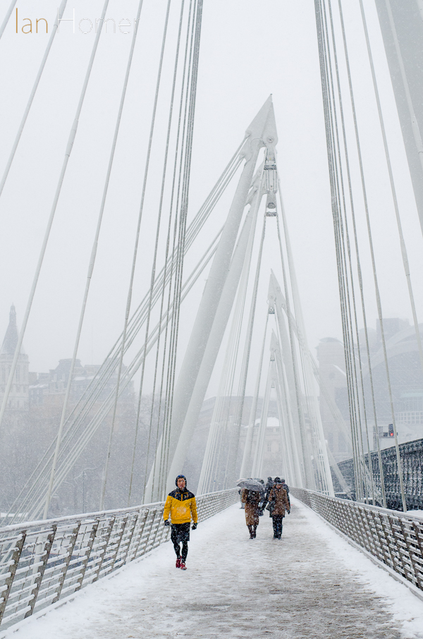 20-1-13 London. A figure in yellow on Hungerford Bridge walkway in the snow