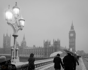 London Snow Scenes: 20-1-13. Central London. Westminster bridge walkers late in the afternoon with the lamps starting to glow.