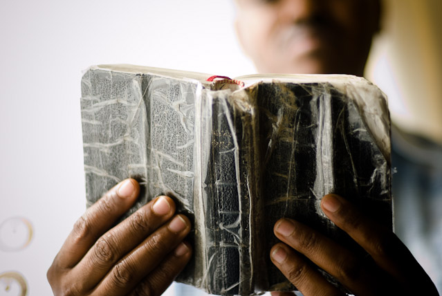 Eritrean refugees in Cardiff: Abraham with the bible he was given on reaching the UK. It's already very well thumbed.